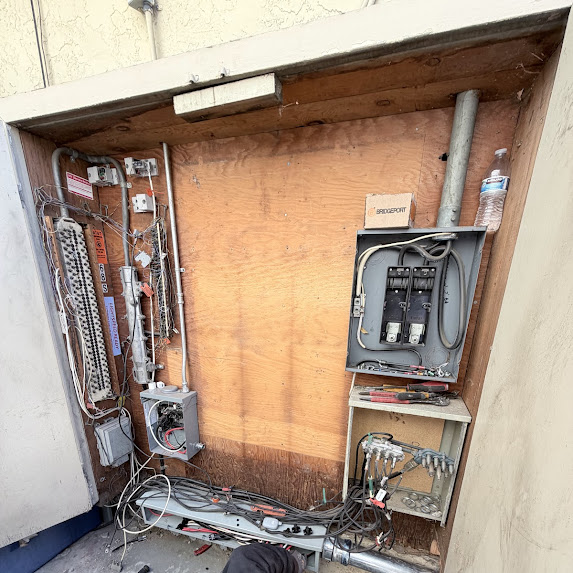 Open electrical service area showing wiring and equipment before commercial panel replacement